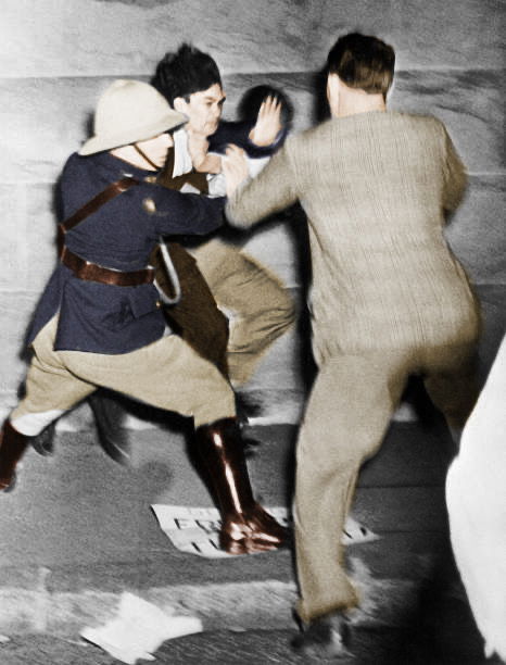 An anti-apartheid protestor jumps two South African police officers (one barely visible) after the police began to arrest a fellow protestor. The Cap, June 1950. [Colourized by me!]