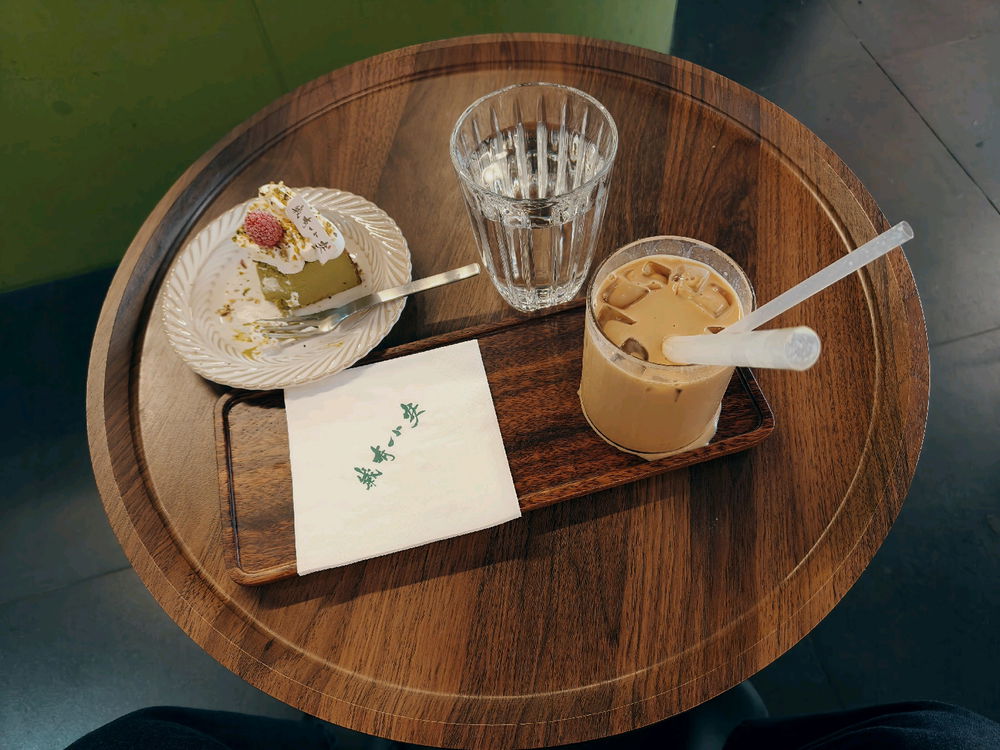 Iced latte with stewed white apricot jam and a pistachio Basque cheesecake.